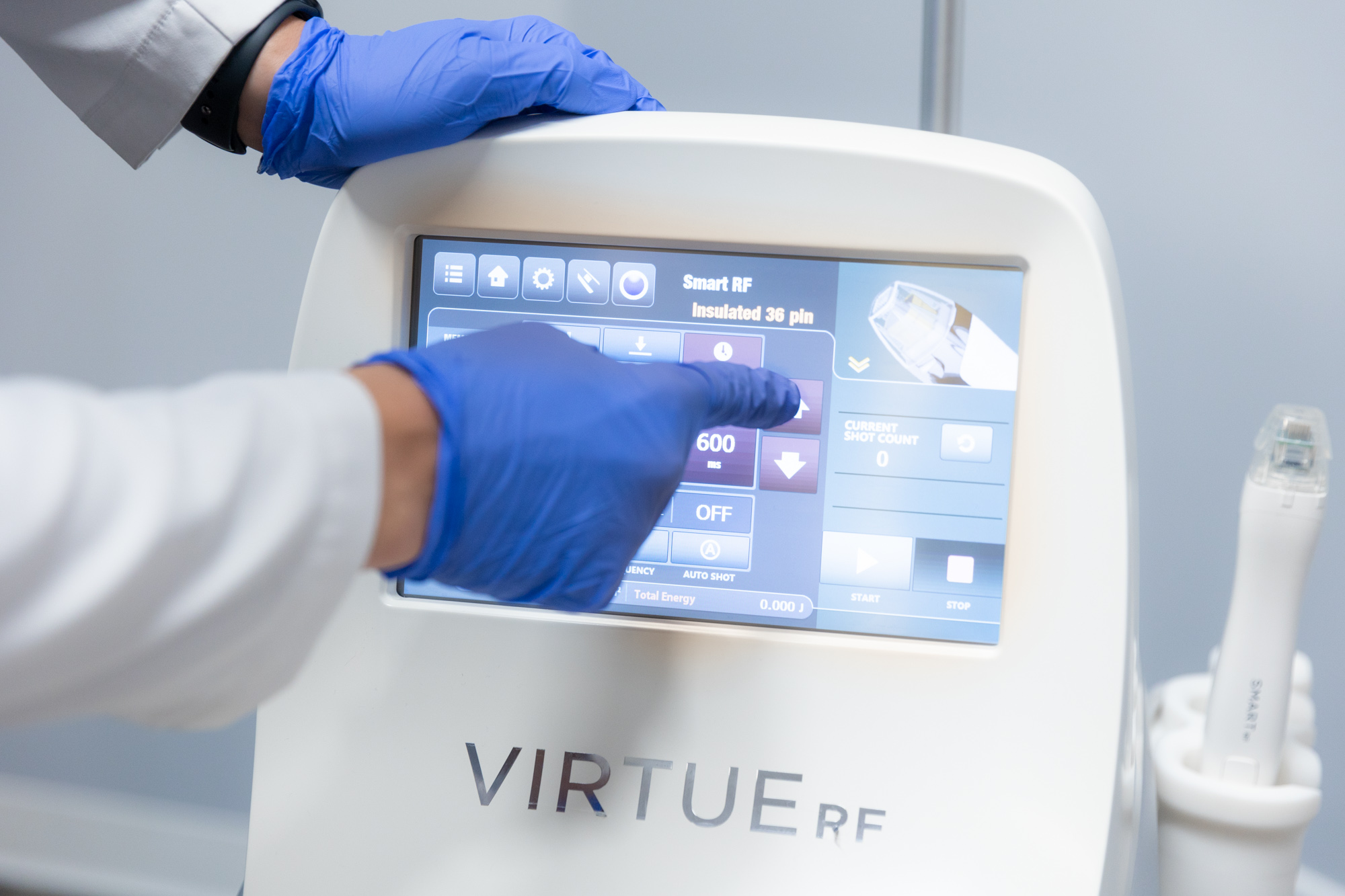 A Radiant Divine provider adjusts the settings on the Virtue RF microneedling platform. Virtue RF skin tightening can be used for a non-surgical mommy makeover