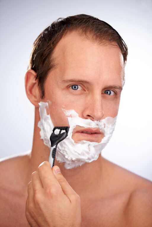 man shaving his face wondering if he can get laser hair removal for men